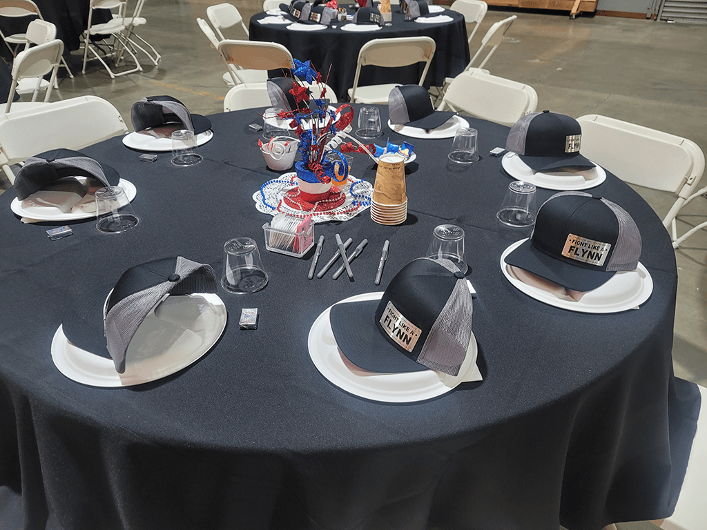 Veteran's Breakfast with custom Michael Flynn metal unique hats set as place holders on event table