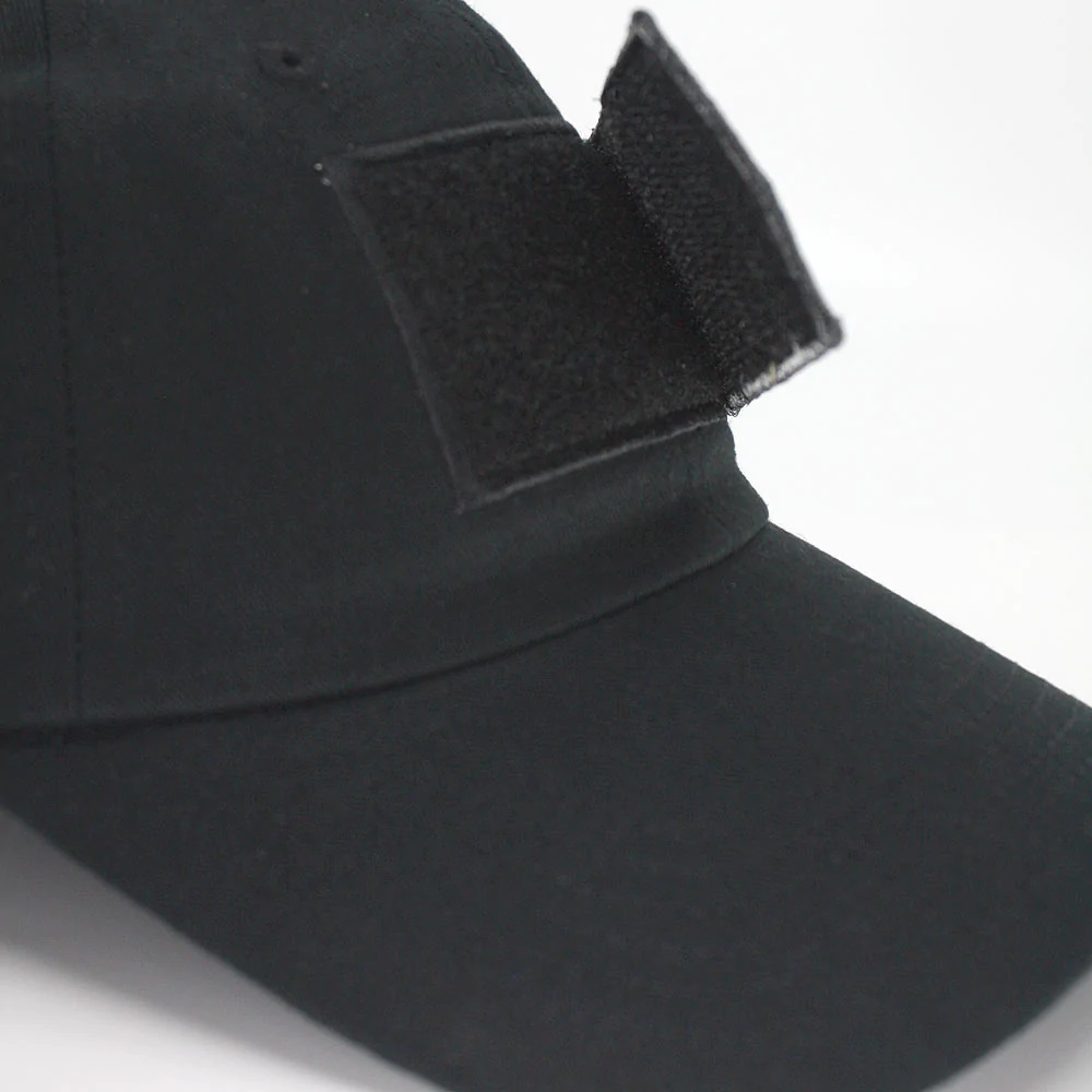 Closeup of black velcro patch hat with patch partially removed to show how it is attached